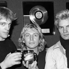 Los componentes de The Police, Sting, Andy Summers y Stewart Copeland, posan con discos de platino de fondo.