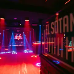 El Sótano, un club techno con luces rojas y azules, pista de baile vacía y DJ listo para la acción.