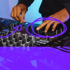 Manos ajustando faders en una mesa de mezclas, clave para aprender como hacer mix de canciones y crear transiciones fluidas.