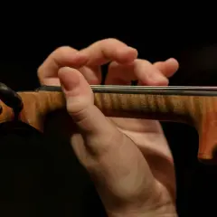 Mano de un violinista tocando con destreza, evocando la maestría de Paganini.