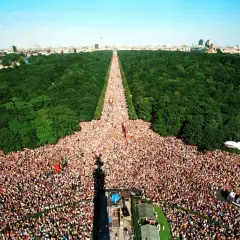 Multitudinaria celebración del Love Parade Berlin, con miles de personas disfrutando en un día soleado.