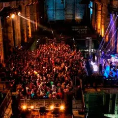 Multitud bailando en un club nocturno con luces de colores, como un **berghain simulator**.
