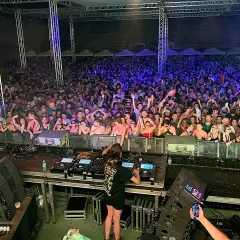 Charlotte de Witte en Málaga, una multitud vibrante baila al ritmo de la música electrónica bajo luces de neón.