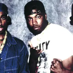 Tres raperos posan para una foto, quizás discutiendo la diferencia entre rap y trap.