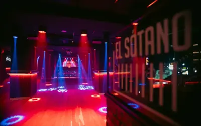 El Sótano, un club techno con luces rojas y azules, pista de baile vacía y DJ listo para la acción.