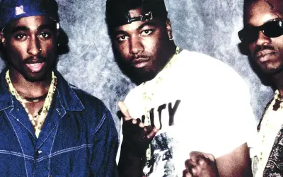 Tres raperos posan para una foto, quizás discutiendo la diferencia entre rap y trap.