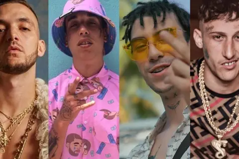 Cuatro artistas de hip hop español posan con cadenas de oro y atuendos llamativos.