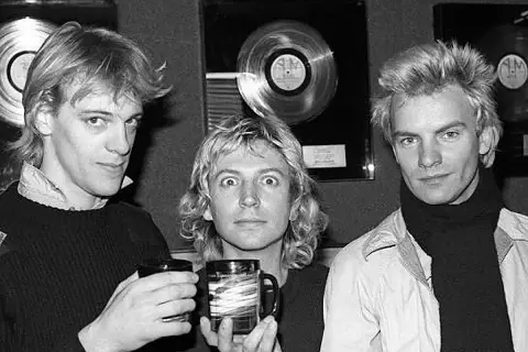 Los componentes de The Police, Sting, Andy Summers y Stewart Copeland, posan con discos de platino de fondo.