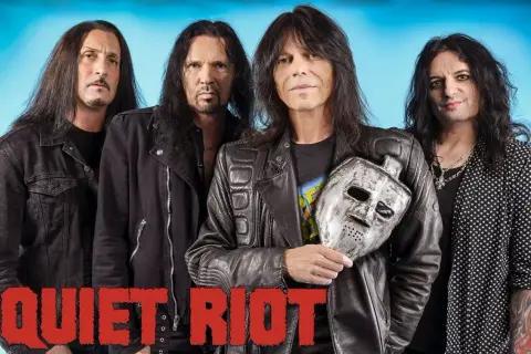 Los miembros de Quiet Riot posan con una máscara de hockey plateada.