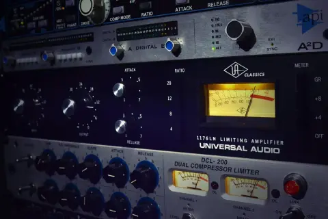 Equipo de audio profesional con medidores VU y controles de ataque, release y ratio. Muestra cómo funciona un compresor en la producción musical.