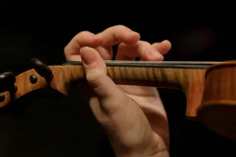 Mano de un violinista tocando con destreza, evocando la maestría de Paganini.