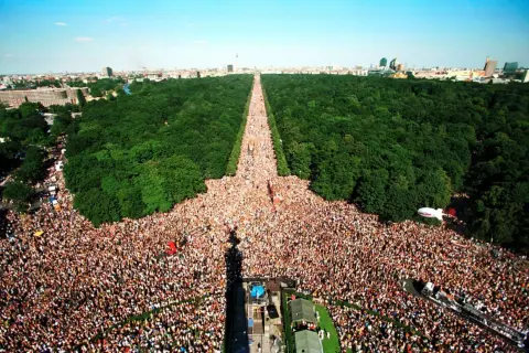 Multitudinaria celebración del Love Parade Berlin, con miles de personas disfrutando en un día soleado.