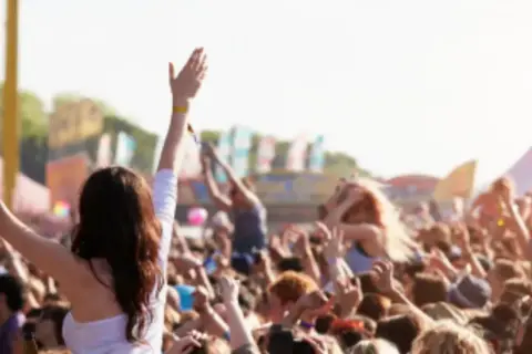 Multitud en un festival, manos al aire, ambiente de rave Madrid.