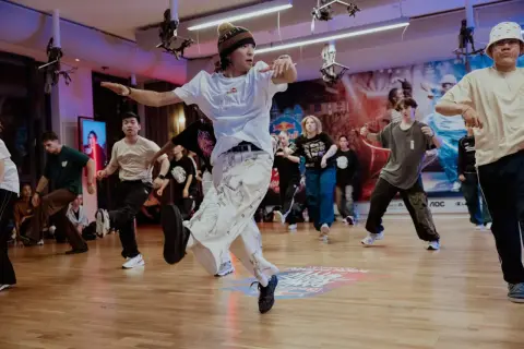 Jóvenes bailando breakdance en un estudio, capturando la energía de cuando se creó el hip hop.