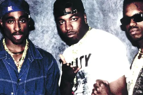 Tres raperos posan para una foto, quizás discutiendo la diferencia entre rap y trap.