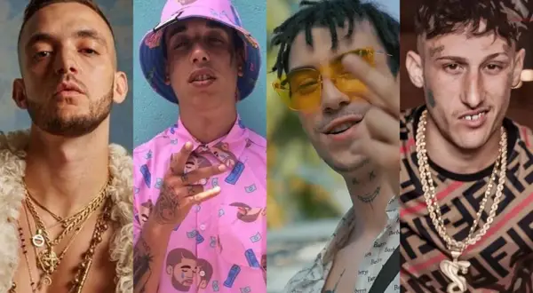 Cuatro artistas de hip hop español posan con cadenas de oro y atuendos llamativos.