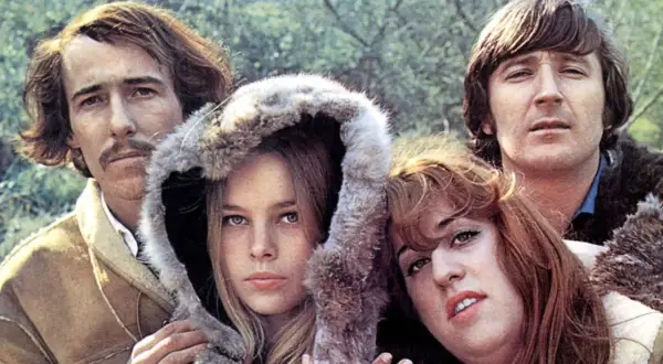 Los miembros de The Mamas & the Papas posan juntos, con un hombre a la izquierda y otro a la derecha, y dos mujeres en el centro.