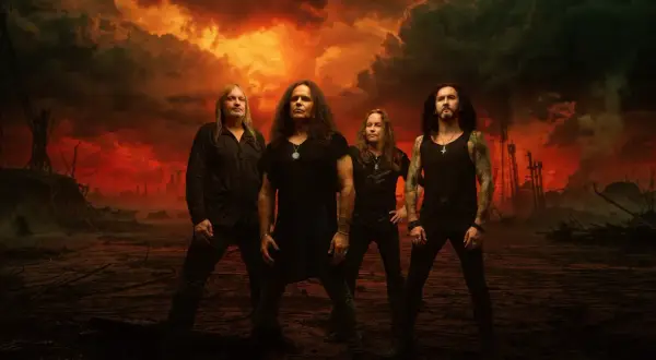 Los miembros de Kreator posan ante un cielo apocalíptico de fuego y humo.