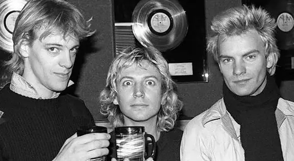 Los componentes de The Police, Sting, Andy Summers y Stewart Copeland, posan con discos de platino de fondo.