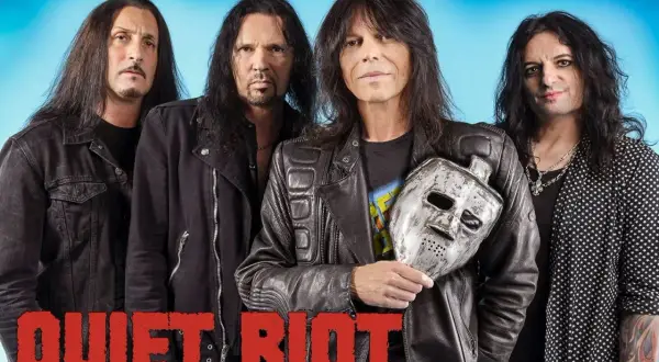 Los miembros de Quiet Riot posan con una máscara de hockey plateada.