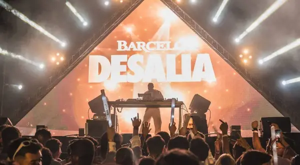 DJ en el escenario de Desalia, con luces y público animado. ¡Así es Desalia!