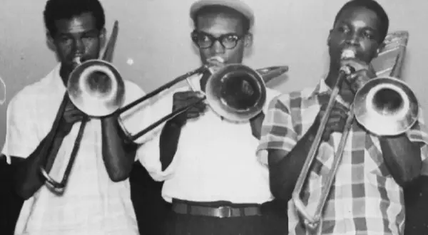 Tres músicos tocando trombones, listos para un concierto de musica ska.