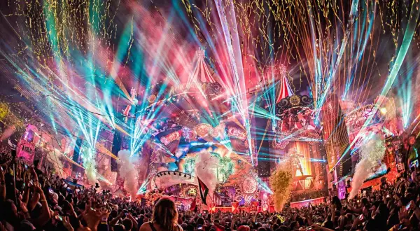 Multitud celebra en Tomorrowland, luces láser, confeti y fuegos artificiales crean un espectáculo mágico. ¡Así es como ir a Tomorrowland!