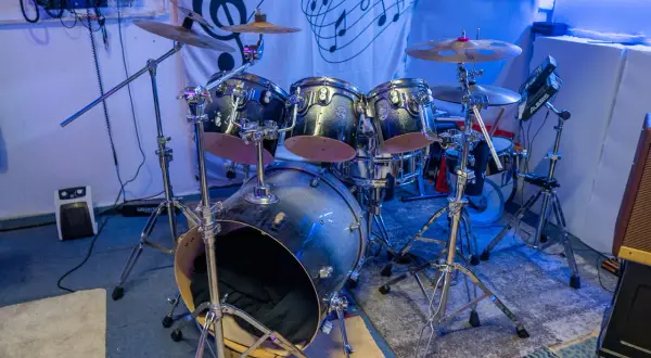 Batería de rock con platillos y un cartel de Bob Marley. ¿Te preguntas dnb que es? Es un género musical.