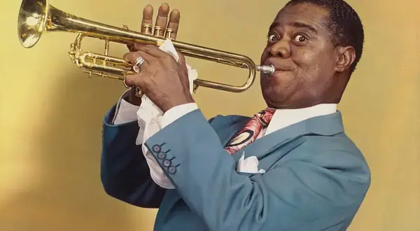 Louis Armstrong, con su trompeta dorada, nos regala una sonrisa y un pañuelo blanco, un detalle curioso del jazz.