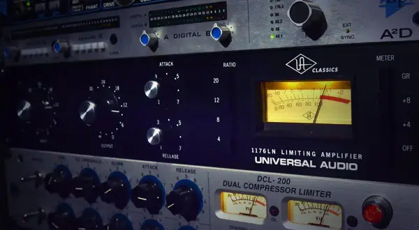 Equipo de audio profesional con medidores VU y controles de ataque, release y ratio. Muestra cómo funciona un compresor en la producción musical.