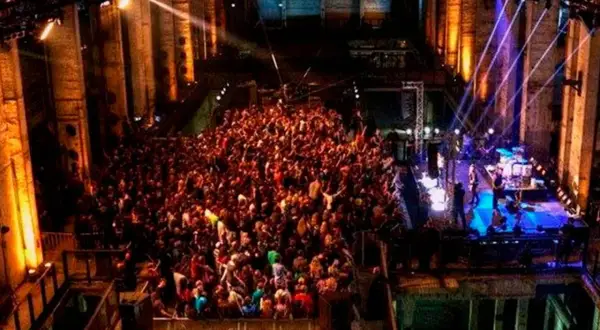 Multitud bailando en un club nocturno con luces de colores, como un **berghain simulator**.