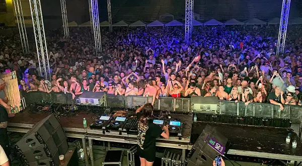 Charlotte de Witte en Málaga, una multitud vibrante baila al ritmo de la música electrónica bajo luces de neón.