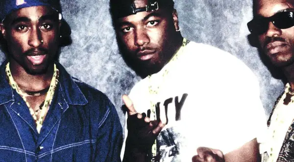 Tres raperos posan para una foto, quizás discutiendo la diferencia entre rap y trap.