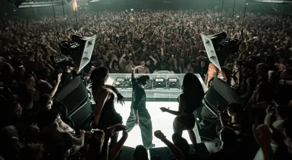 El DJ Klangkuenstler domina el escenario en un club lleno de gente, creando una atmósfera de otro mundo.