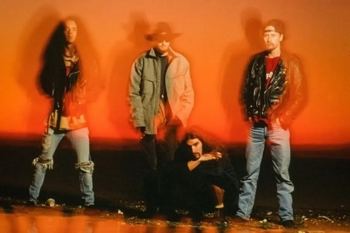 Los miembros de Alice in Chains posan con un fondo naranja vibrante.