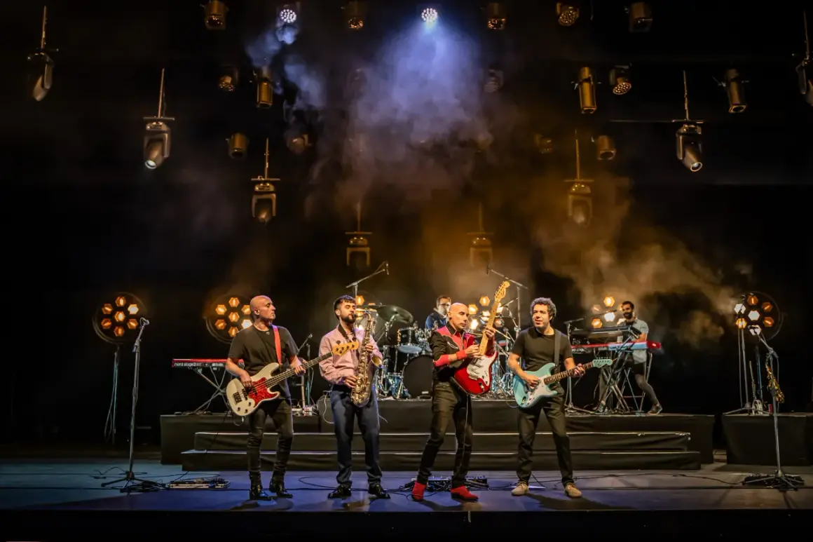 Cinco músicos en el escenario, con guitarras, bajo, saxofón y teclados. La banda, como si fueran hermanos, comparte sus opiniones musicales.