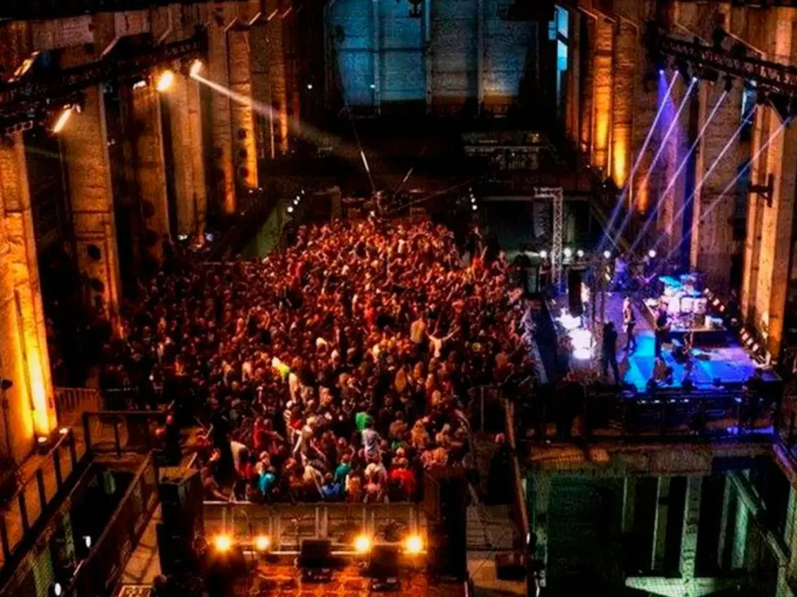 Multitud bailando en un club nocturno con luces de colores, como un **berghain simulator**.