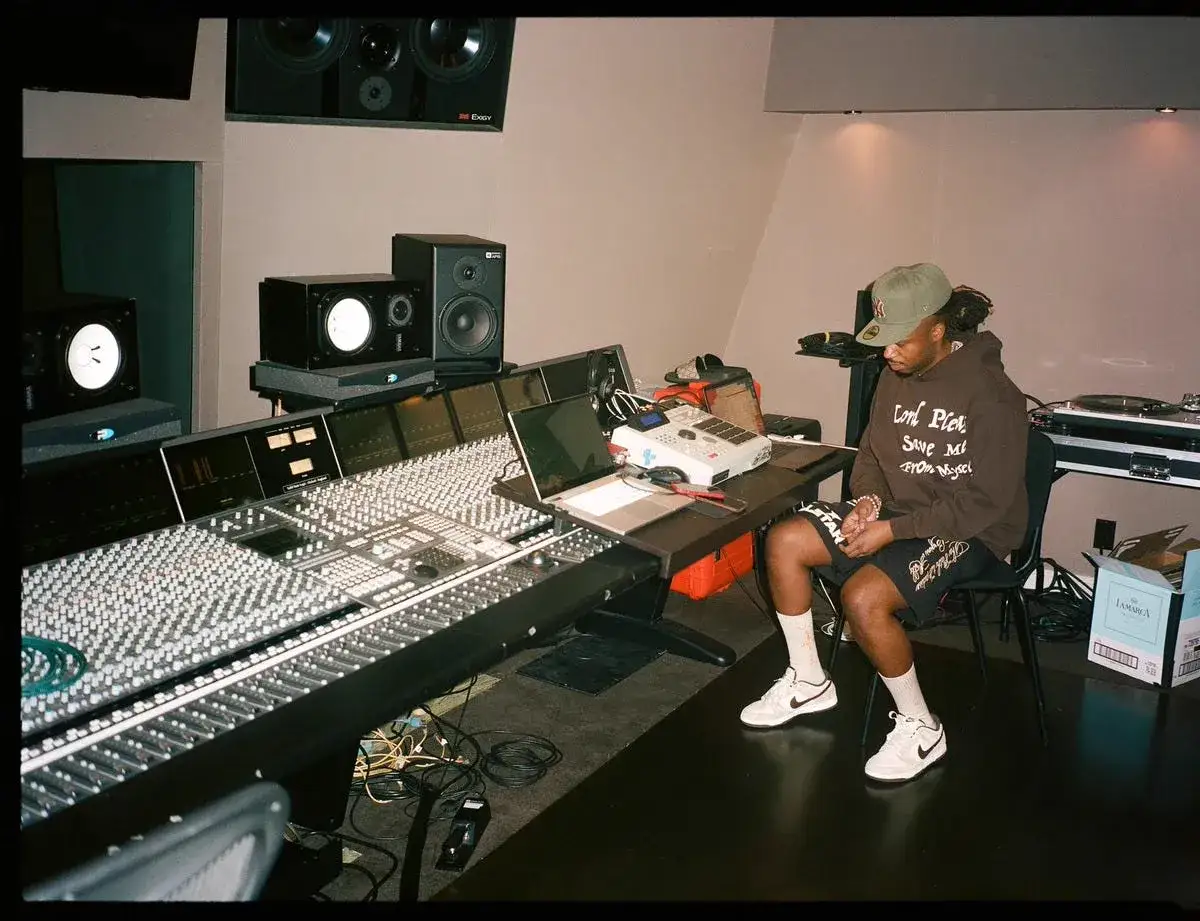 Productor en estudio de grabaci&oacute;n, rodeado de equipo, quiz&aacute;s creando la diferencia entre rap y trap.