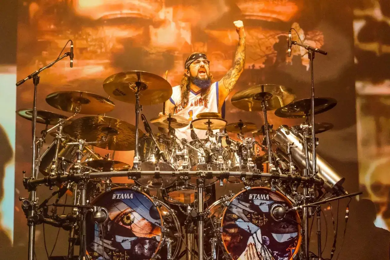 Mike Portnoy, baterista de la banda, con el puño en alto, tocando su impresionante batería Tama.