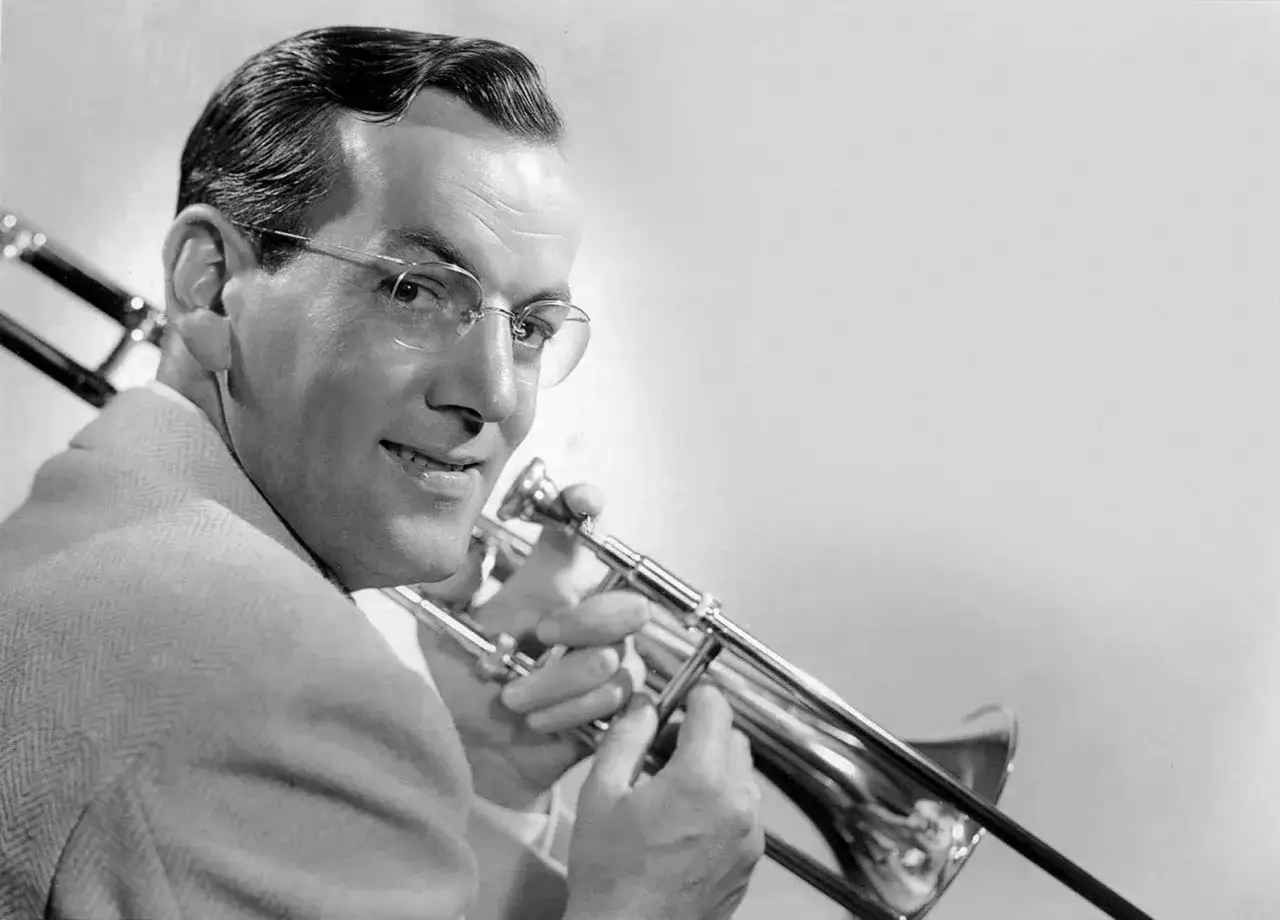 M&uacute;sico con gafas tocando tromb&oacute;n, evocando la era dorada de las big bands famosas.