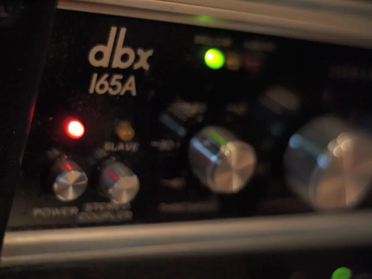 Panel frontal de procesadores de dinámica dbx 165A con luces indicadoras y perillas.