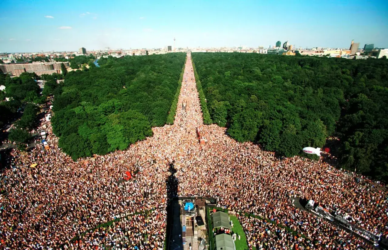 Multitudinaria celebraci&oacute;n del Love Parade Berlin, con miles de personas disfrutando en un d&iacute;a soleado.