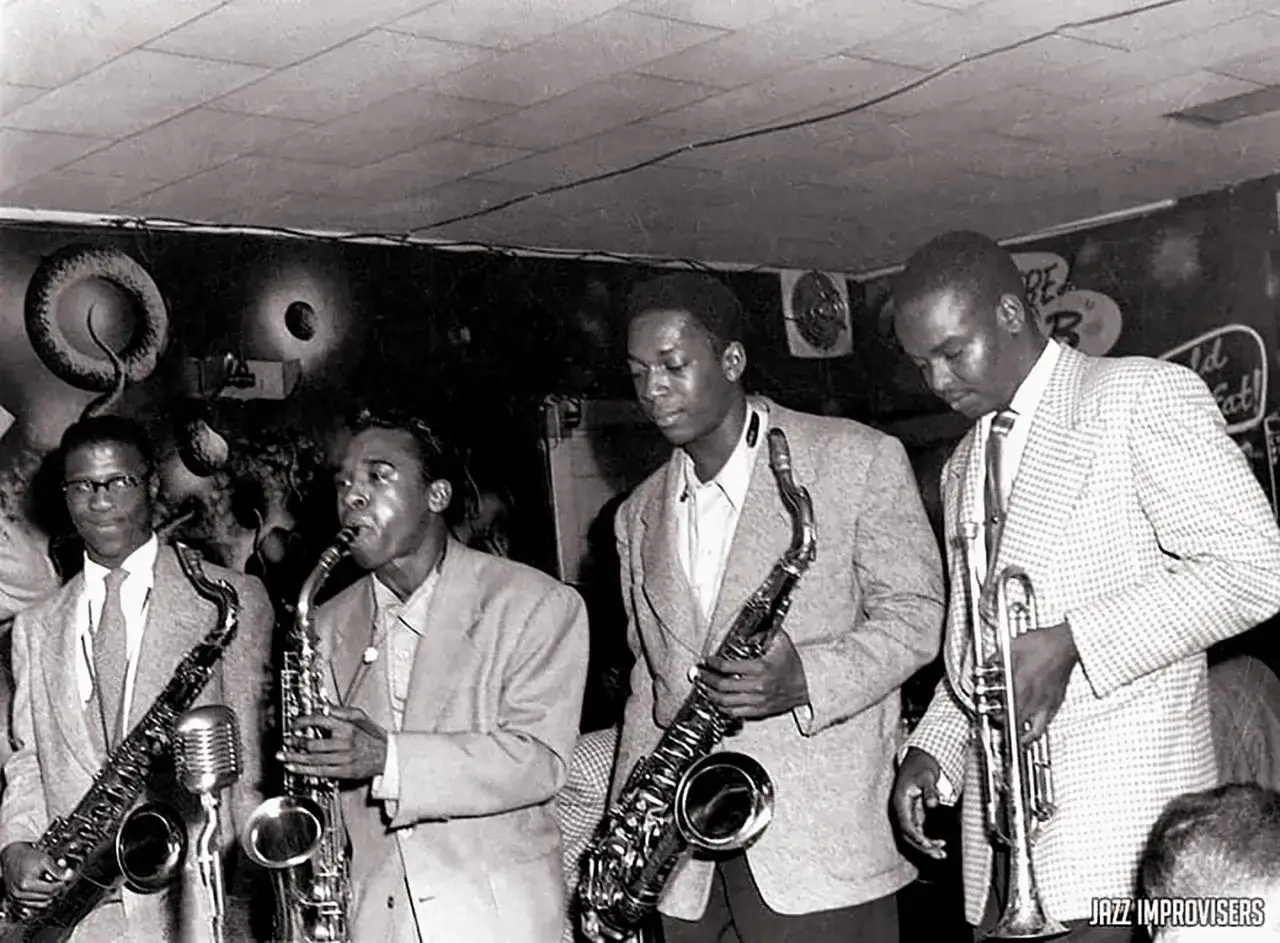 Cuatro m&uacute;sicos de jazz de los a&ntilde;os 50, con saxofones y trompeta, listos para improvisar.