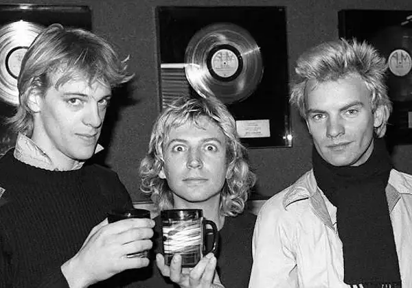 Los componentes de The Police, Sting, Andy Summers y Stewart Copeland, posan con discos de platino de fondo.