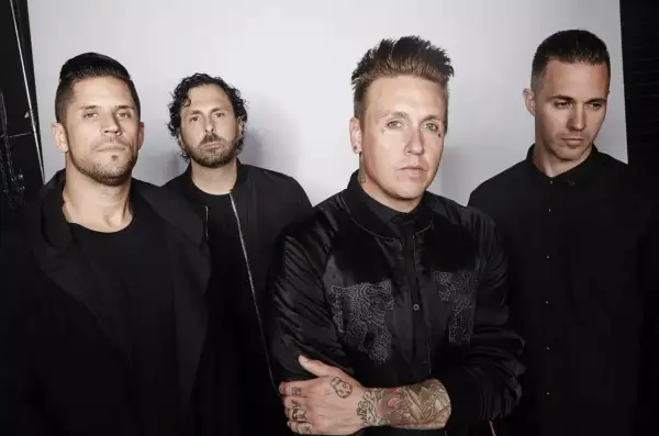 Los miembros de Papa Roach posan juntos, vestidos de negro, con miradas intensas.