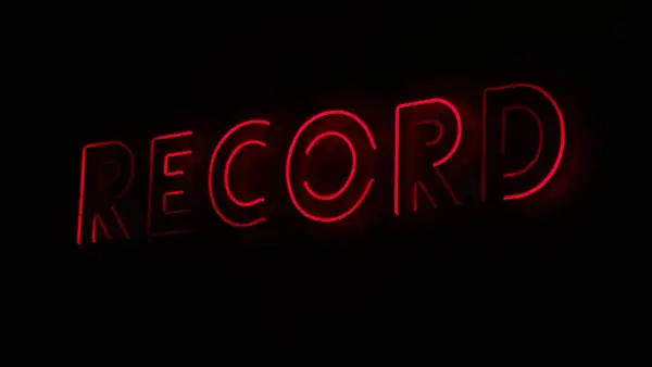 Letrero de neón rojo con la palabra "RECORD", evocando la era dorada de los sellos discográficos y la música.
