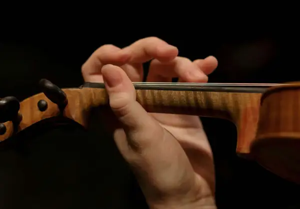 Mano de un violinista tocando con destreza, evocando la maestría de Paganini.