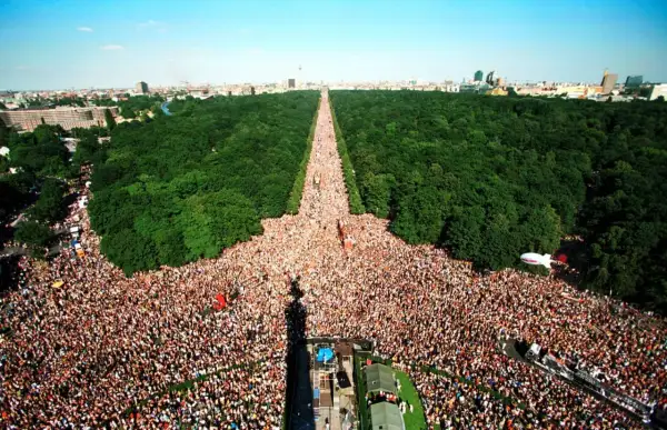 Multitudinaria celebración del Love Parade Berlin, con miles de personas disfrutando en un día soleado.