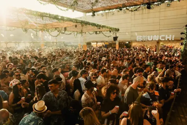 Multitud disfrutando de un día soleado en Brunch! Electronic Málaga, con música y buen ambiente.