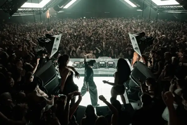El DJ Klangkuenstler domina el escenario en un club lleno de gente, creando una atmósfera de otro mundo.